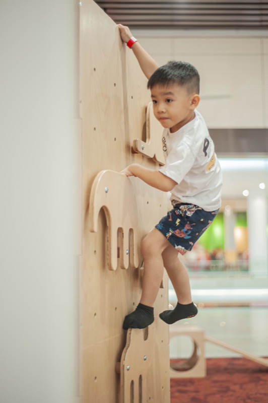 Child climbing wooden climbing wall